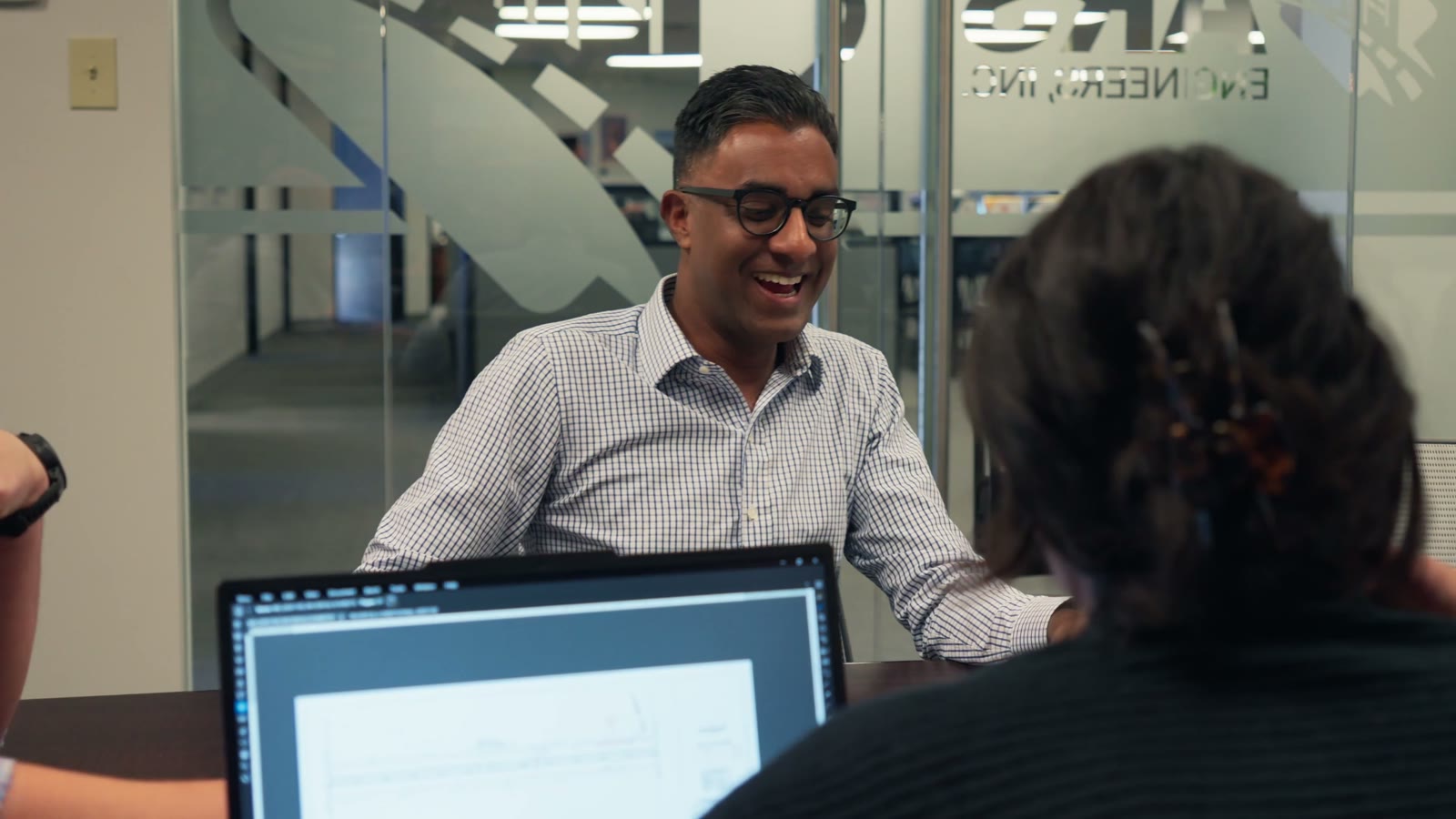 Engineers laughing in a meeting at the ARS Engineering office